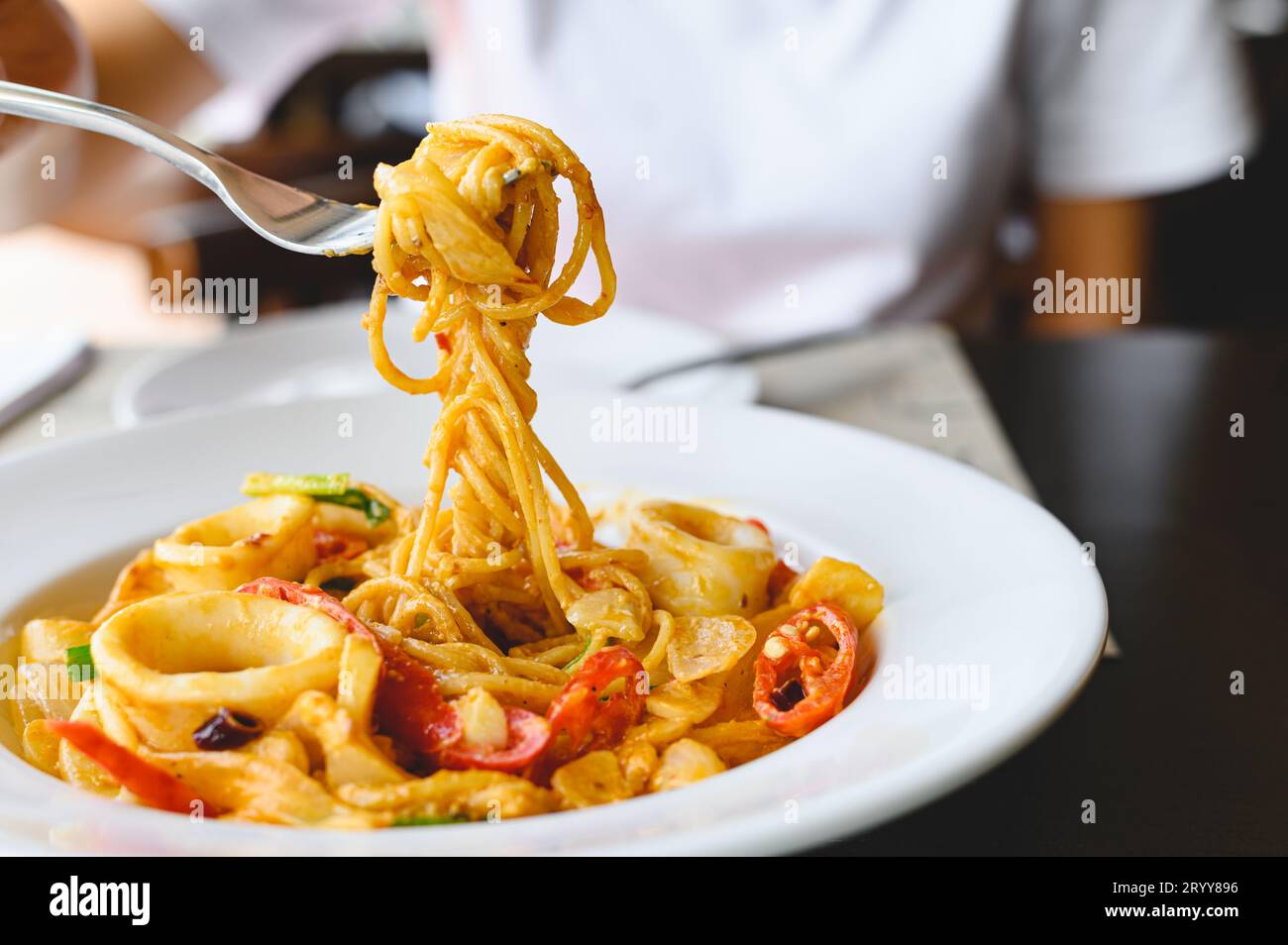 Frau essen Meeresfrüchte Spaghetti weiße Sauce mit einer Gabel im italienischen Restaurant. Essen und Küche Konzept. Stockfoto