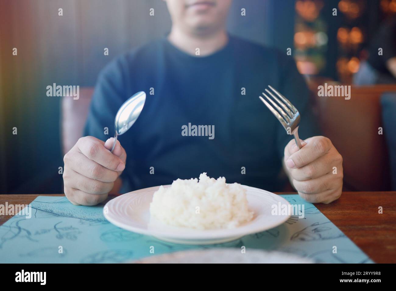 Mann isst Reis und genießt eine Mahlzeit im Restaurant. Mann beim Abendessen. Stockfoto