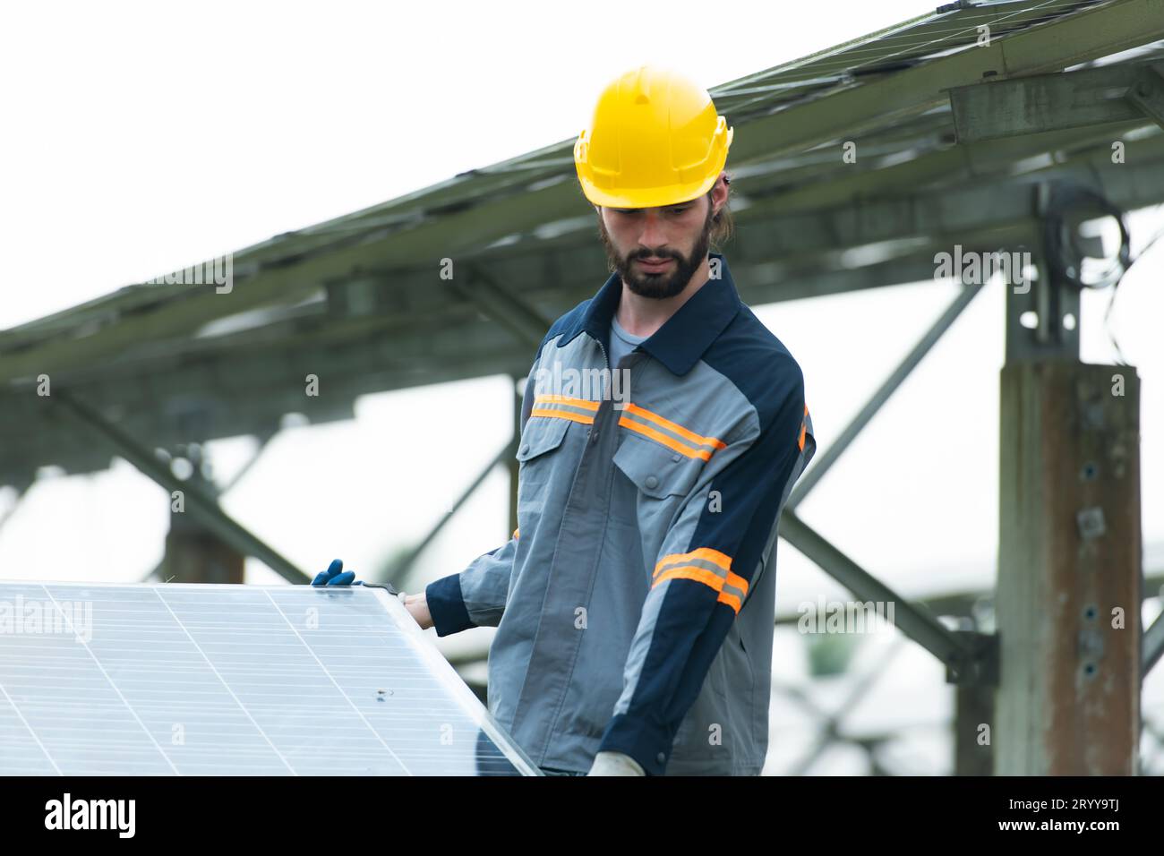 Ingenieure und Techniker entladen reparierte Solarpaneele, die auf den Reihen von Solarzellen installiert werden sollen, die an Hunderten von Wechselstrom angeordnet sind Stockfoto