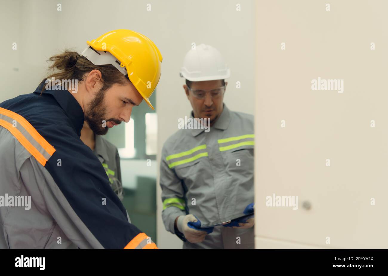Team der Elektrotechnik, das das System eines großen Solarspeichers in der Mitte des Solar-ce-Feldes überprüft Stockfoto
