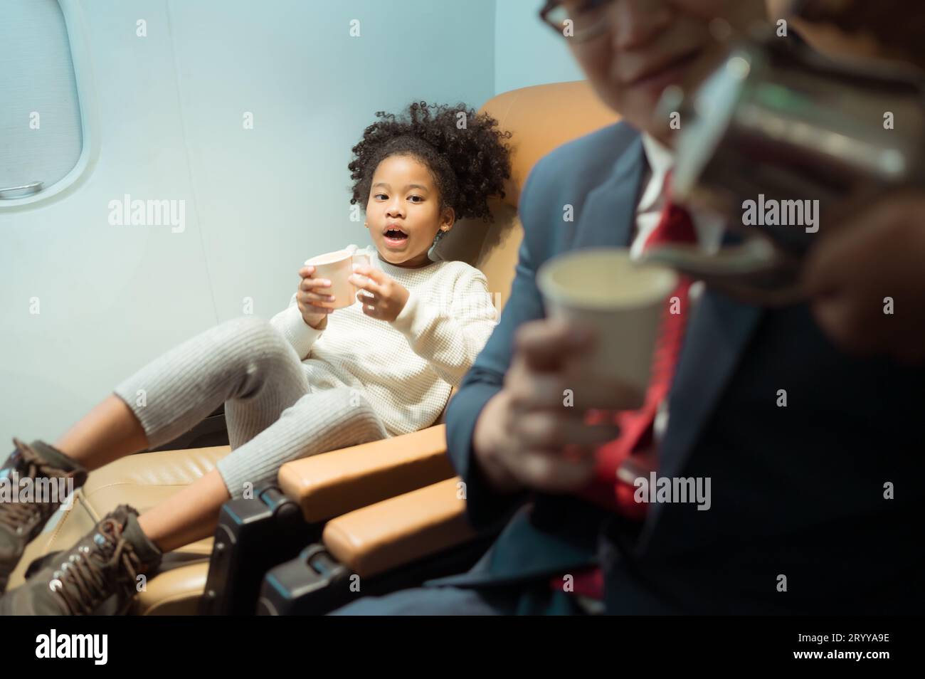 Die Flugbegleiterin serviert den Passagieren der Business Class Getränke Stockfoto