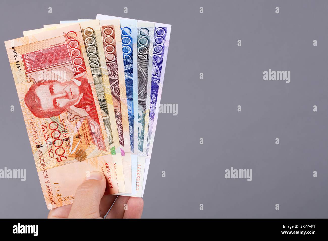 Altes venezolanisches Geld in der Hand auf grauem Hintergrund Stockfoto