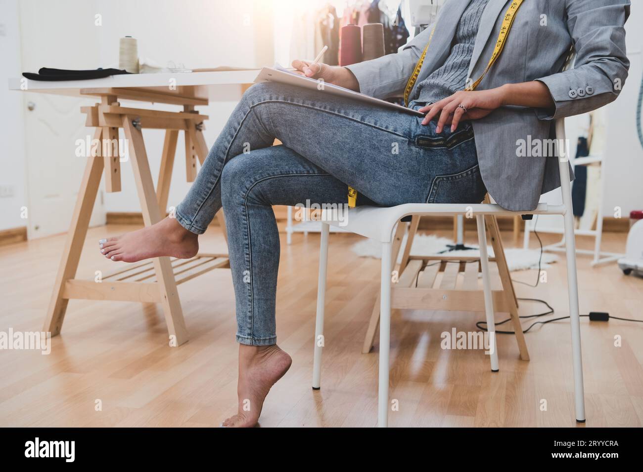 Attraktive asiatische Modedesignerin, die in der Werkstatt für das Home Office arbeitet. Stilvolle Fashionista-Frau kreiert neues Stoffdesign Co Stockfoto