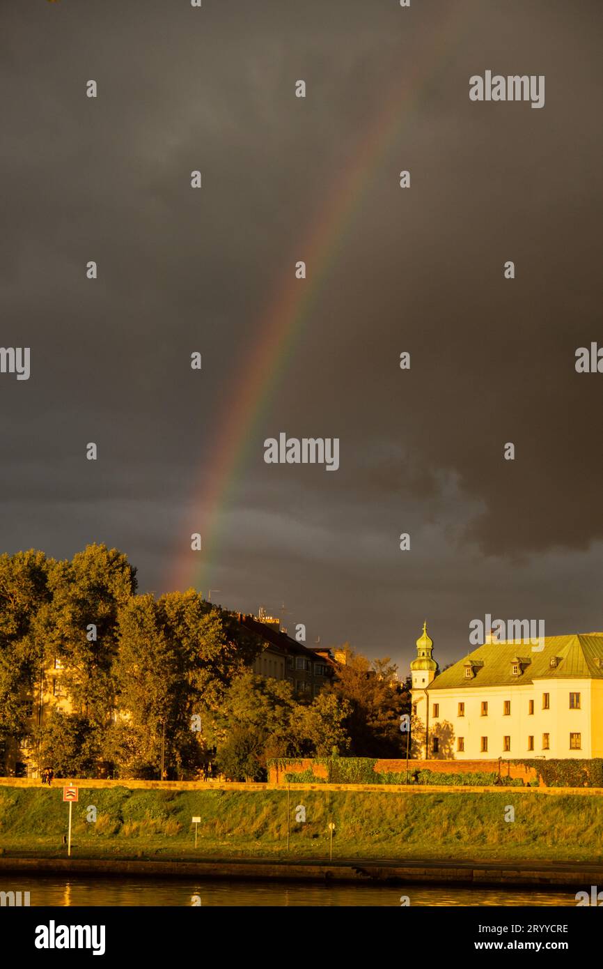 Starker Regen und Regenbogen über der Weichsel in Krakau Polen. Atemberaubende Aussicht auf die Regenzeit und den Regenbogen der Stadt Stockfoto