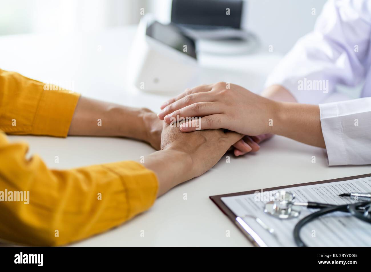 Arzt im Gesundheitswesen. Berufsarzt im weißen Uniform-Mantel Interview mit dem Patienten, der seine männliche Patie beruhigt Stockfoto