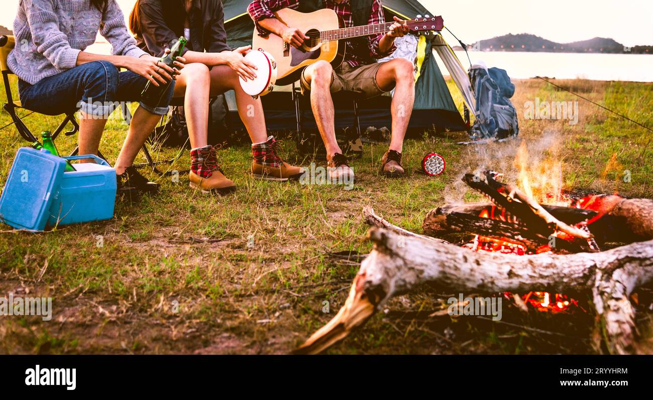 Reisende, die campen, Picknick machen und Musik auf dem Wiesen spielen. Berg- und See-Hintergrund. Das Konzept der Menschen und Lebensstile. O Stockfoto