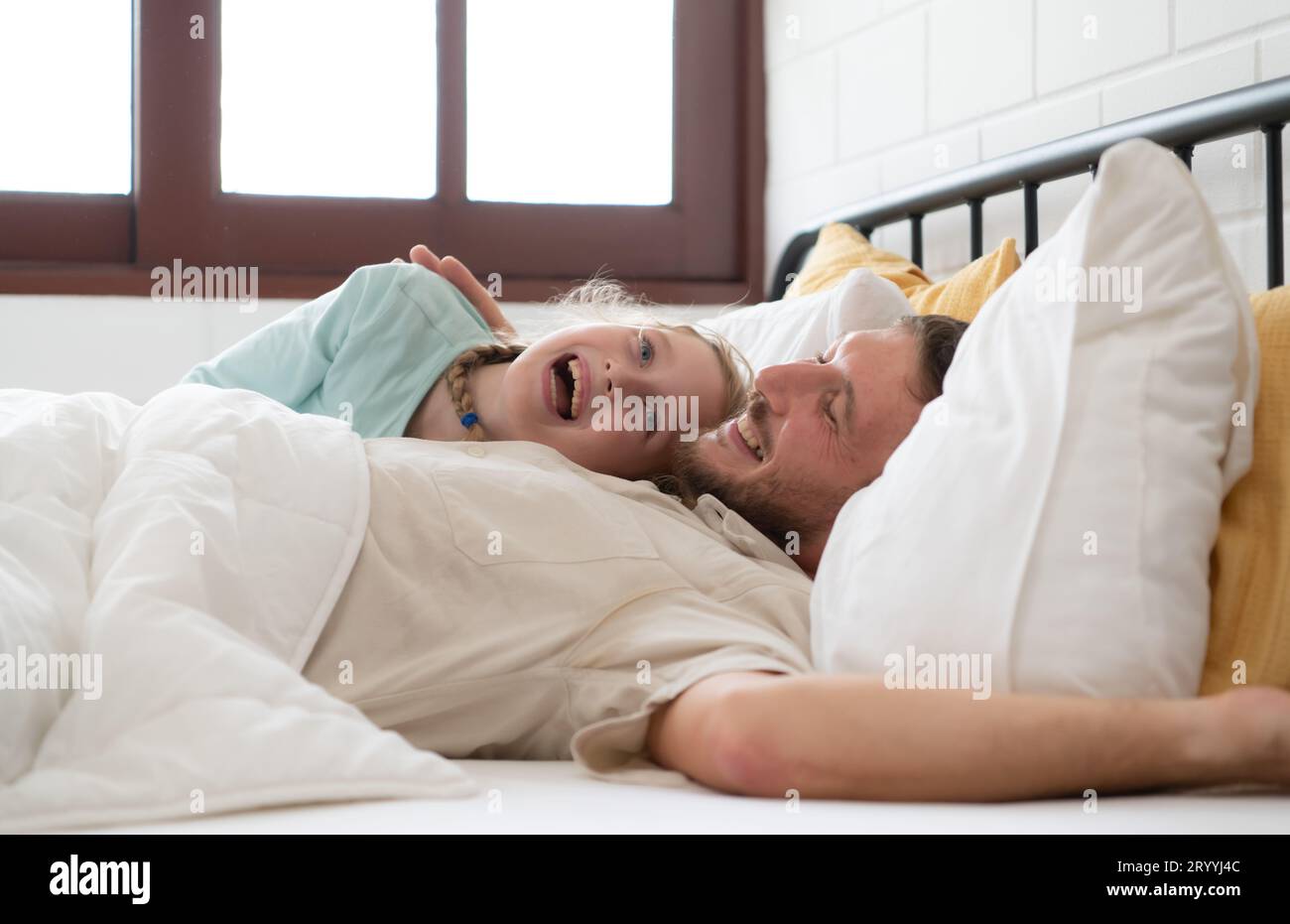 Ein Vater spricht gern mit seiner Tochter in seinem Schlafzimmer. Bevor er sich verabschiedet und ihre Tochter ins Bett schickt Stockfoto