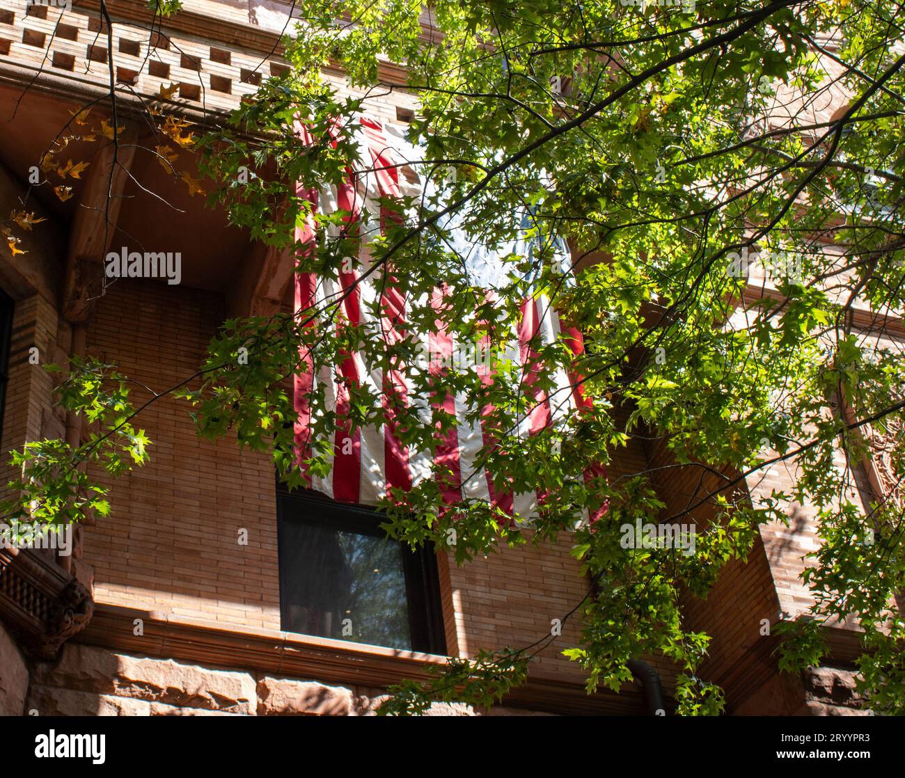 Die amerikanische Flagge hängt im Sandsteingebäude Stockfoto