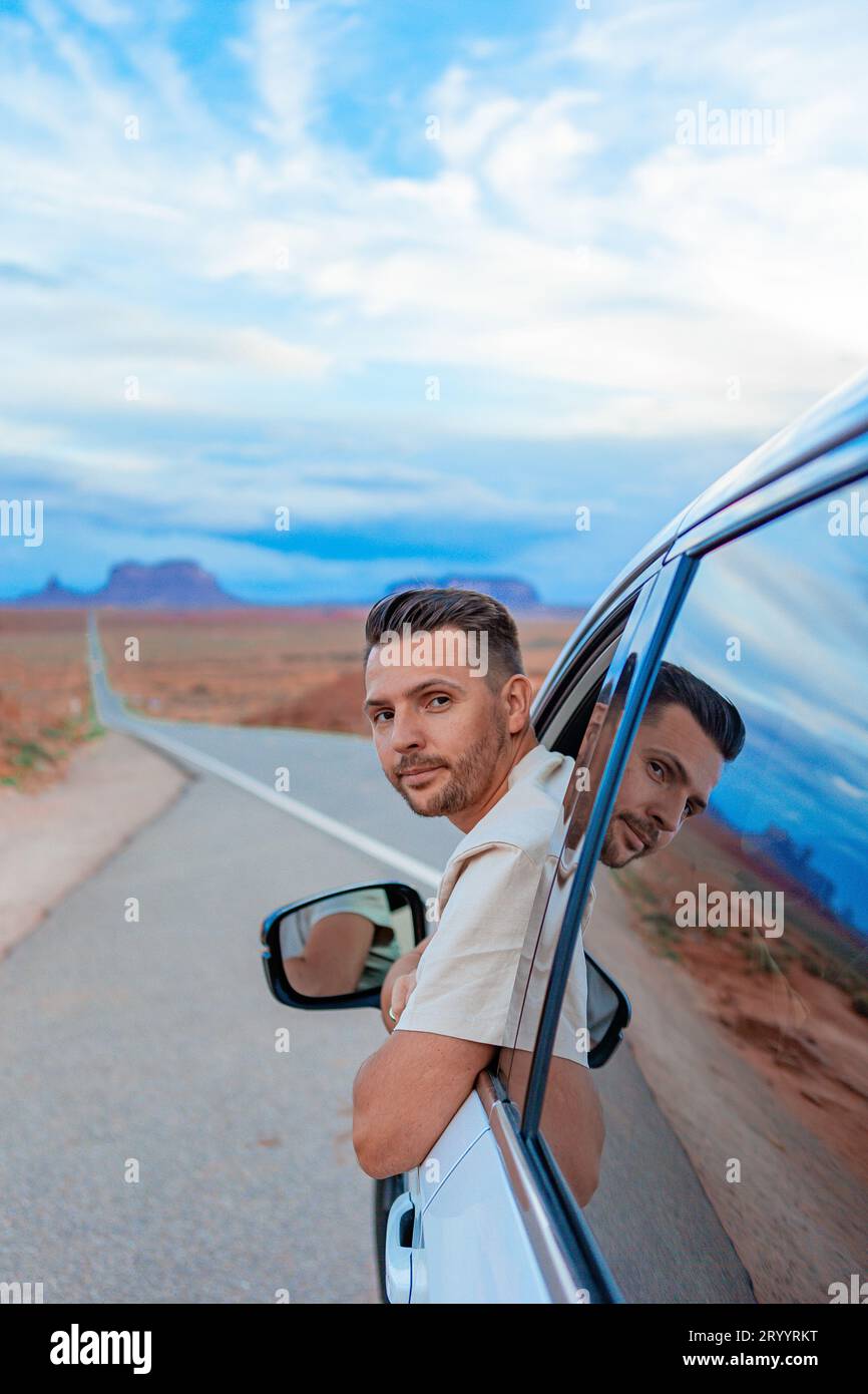 Junger Mann, der mit dem Auto im berühmten Monument Valley in Utah unterwegs ist Stockfoto