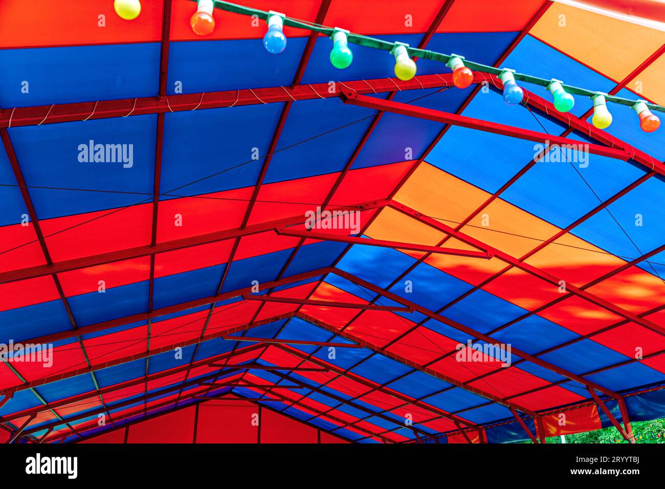 Farbenfrohe Decke des Pavillons mit altmodischen elektrischen Lampen im Vergnügungspark der Stadt. Stockfoto