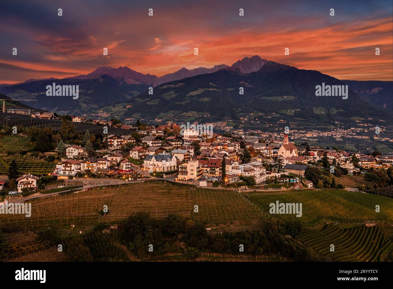 Tirol, Italien - aus der Vogelperspektive von Tirol (Dorf Tirol), einer Gemeinde im Nordwesten der Stadt Bolsano bei Sonnenuntergang mit wunderschönem goldenen Himmel und Clo Stockfoto