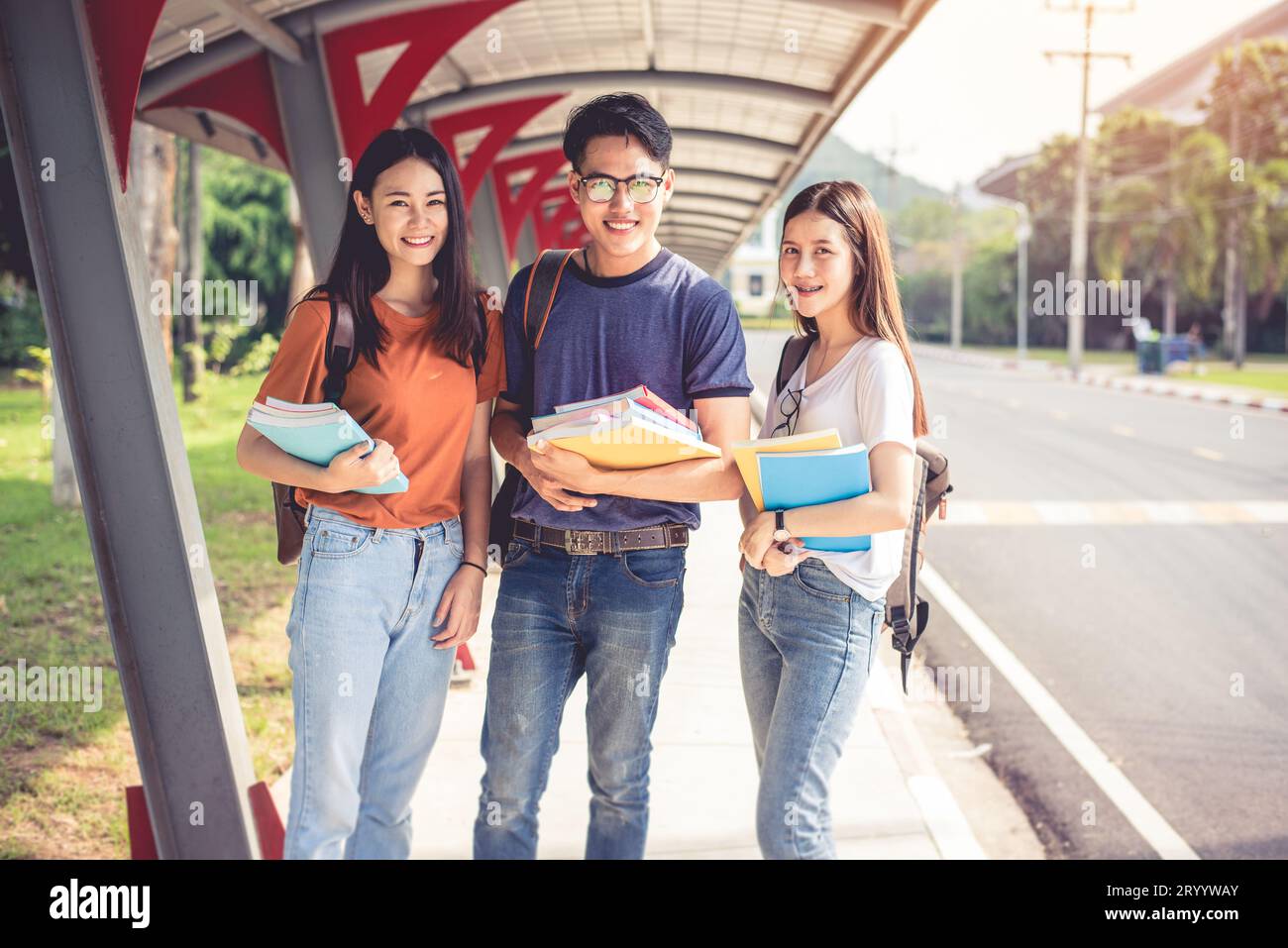 Drei junge asiatische Campus-Studenten genießen es, gemeinsam Nachhilfe zu geben und Bücher zu lesen. Freundschaft und Bildungskonzept. Campus-Schule und Stockfoto