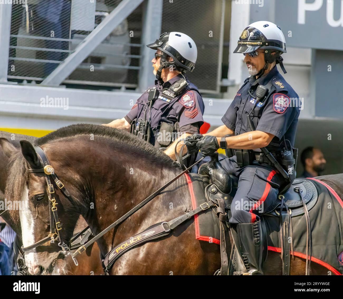 Calgary, Alberta, Kanada. Juli 2023. Ein paar Polizisten, die bei einer öffentlichen Parade mit Helmen auf Pferden reiten Stockfoto