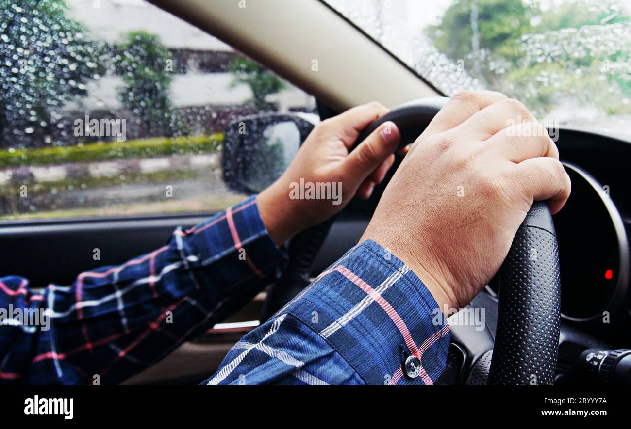 Geschäftsmann, der mit beiden Händen am Lenkrad fährt, selektiver Fokus. Sicherheitsfahrkonzept. Stockfoto