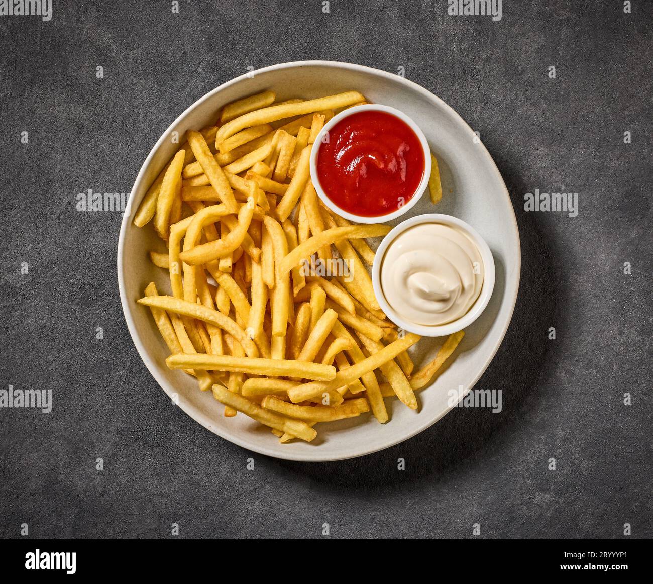 Teller mit Pommes frites mit Ketchup und Mayonnaise auf dunkelgrauem Tisch, Draufsicht Stockfoto