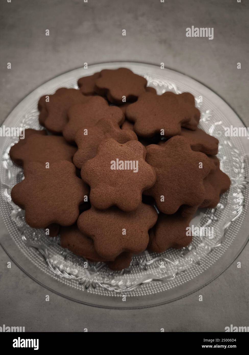 Plätzchen in Form von Schokoladenblumen auf Glasplatte gestapelt weihnachten Kopierraum Stockfoto