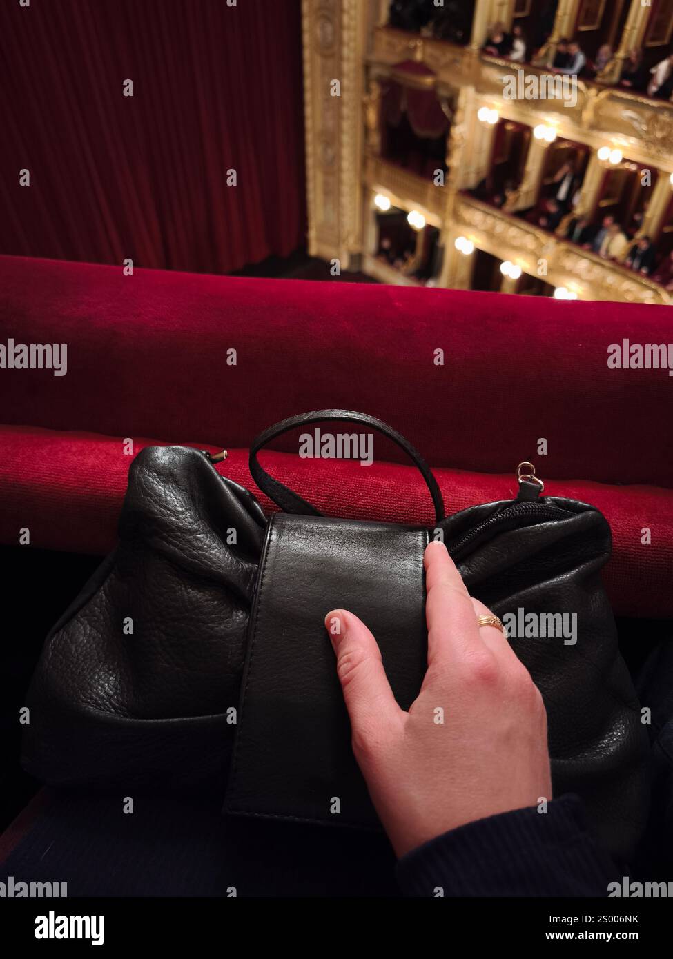 Prag, Tschechische republik - 17. Dezember 2024: Frau mit schwarzer Ledertasche in der Nationalen Theaterbox Stockfoto