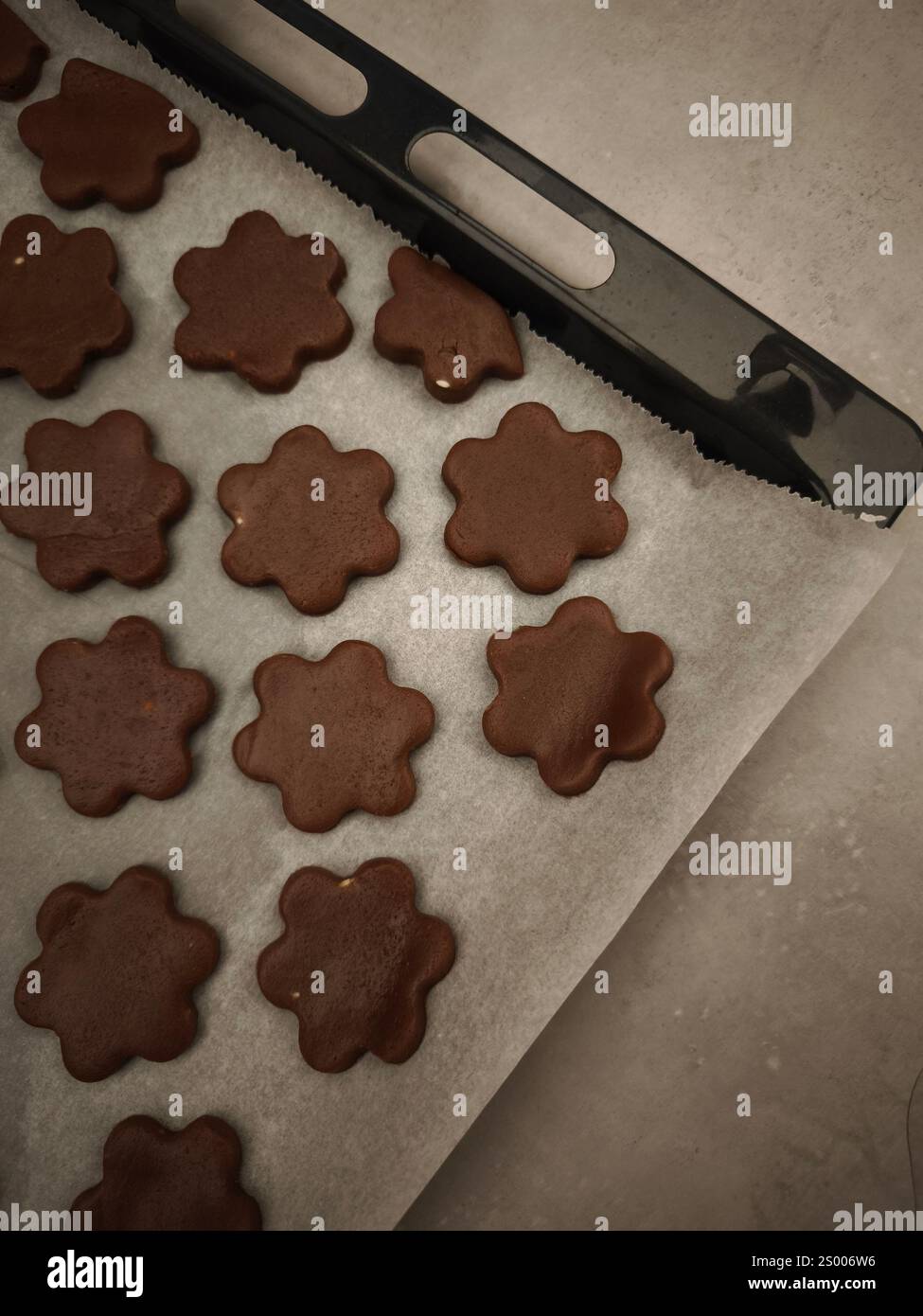 Plätzchen in Form von Schokoladenblumen, die auf einem Tablett backen, weihnachten, Kopierraum Stockfoto