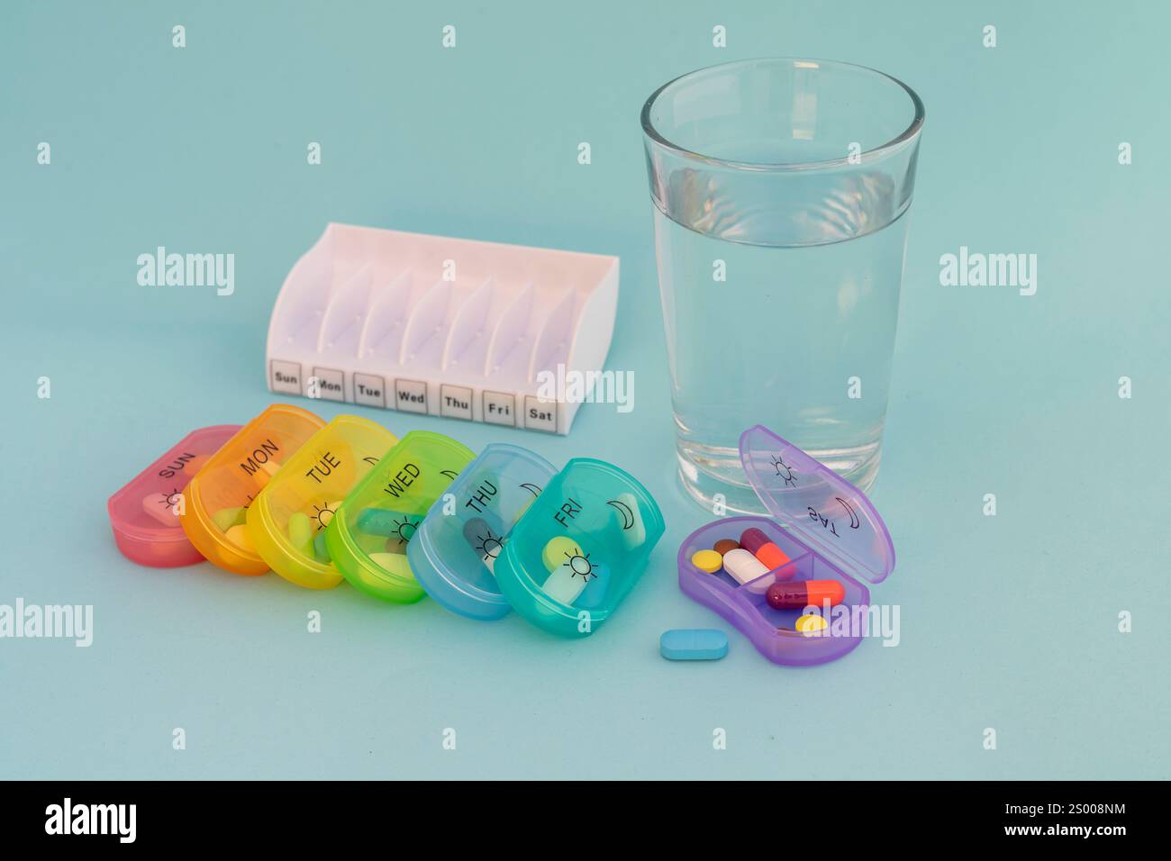 Medizin für sieben Tage in sieben Plastikkisten auf blauem Hintergrund Stockfoto