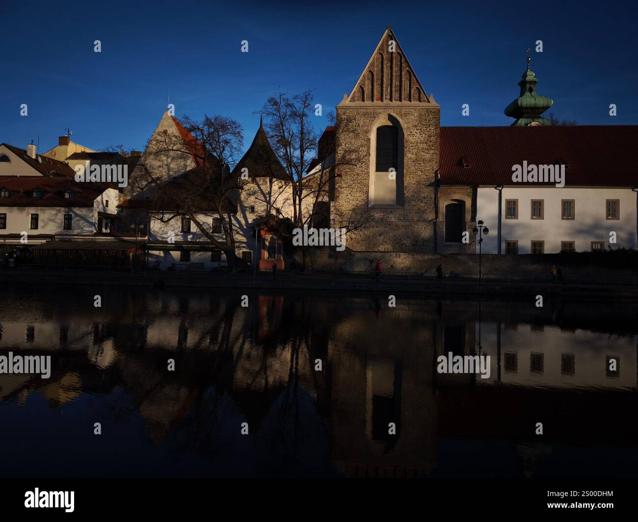 Ceske budejovice, Tschechische republik - 21. Dezember 2024: Dominikanerkloster reflektiert auf dem Malse-Fluss zur weihnachtszeit Stockfoto