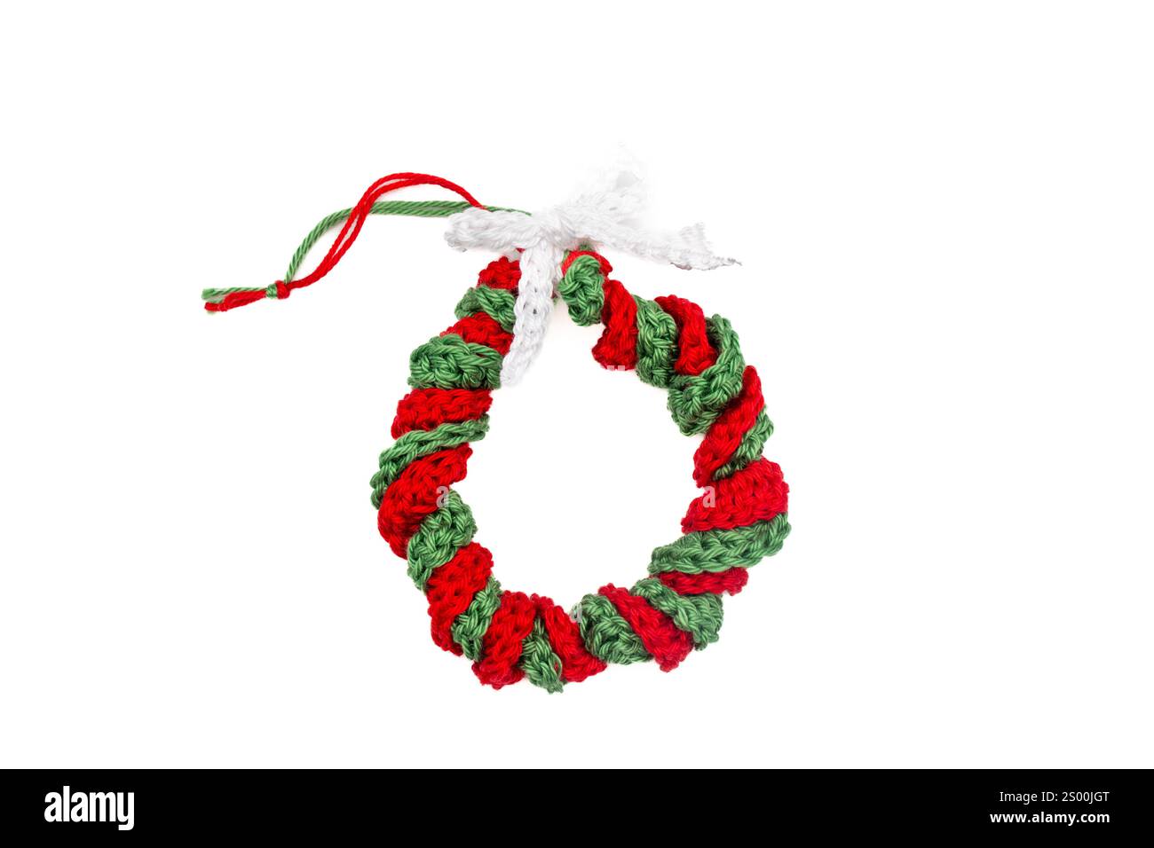 Handgemachte gehäkelte Weihnachtskranz Ornament in Rot und Grün auf weißem Hintergrund Stockfoto