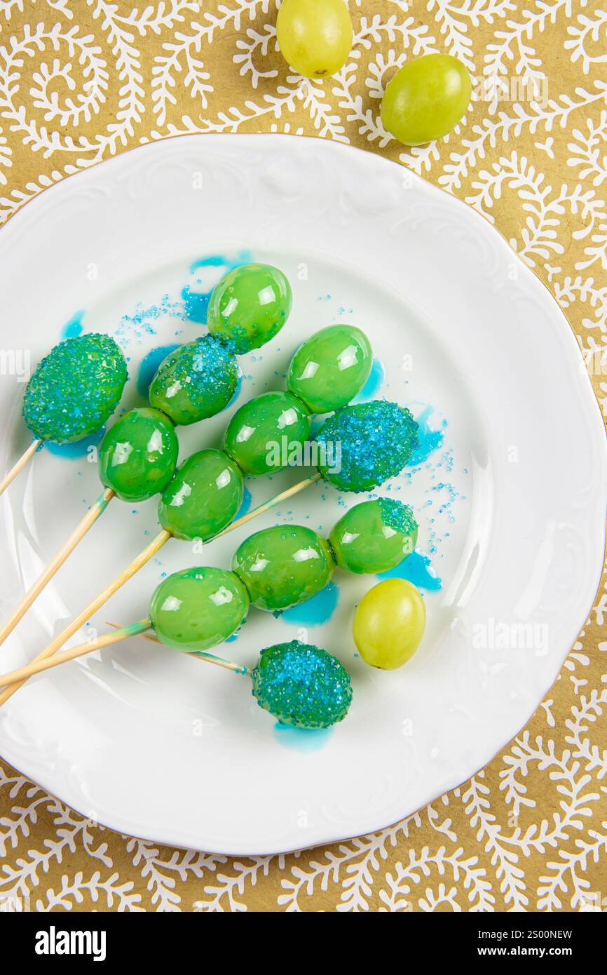 Karamellisierte oder kandierte Früchte Trauben genannt Tanghulu. Süße frische zuckerhaltige Snacks auf weißem Teller, Studio-Aufnahme. Trauben mit Zuckerüberzug. Stockfoto