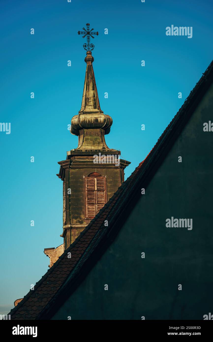 Der alte katholische Kirchturm gegen den blauen Himmel Stockfoto