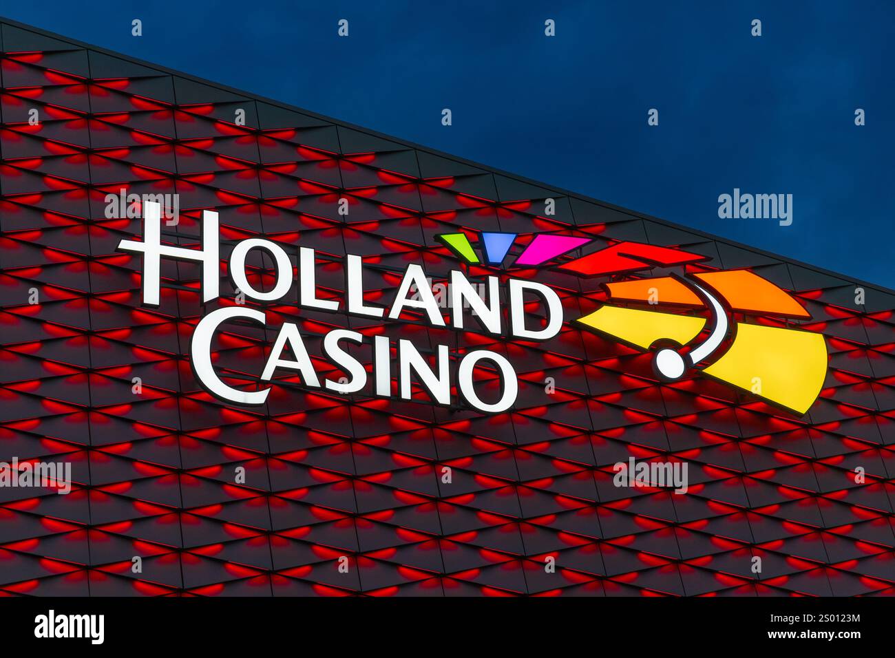 Utrecht, Niederlande. 25. september 2024. Buntes Holland Casino-Logo, beleuchtet bei Nacht auf dem rot beleuchteten Gebäude Stockfoto