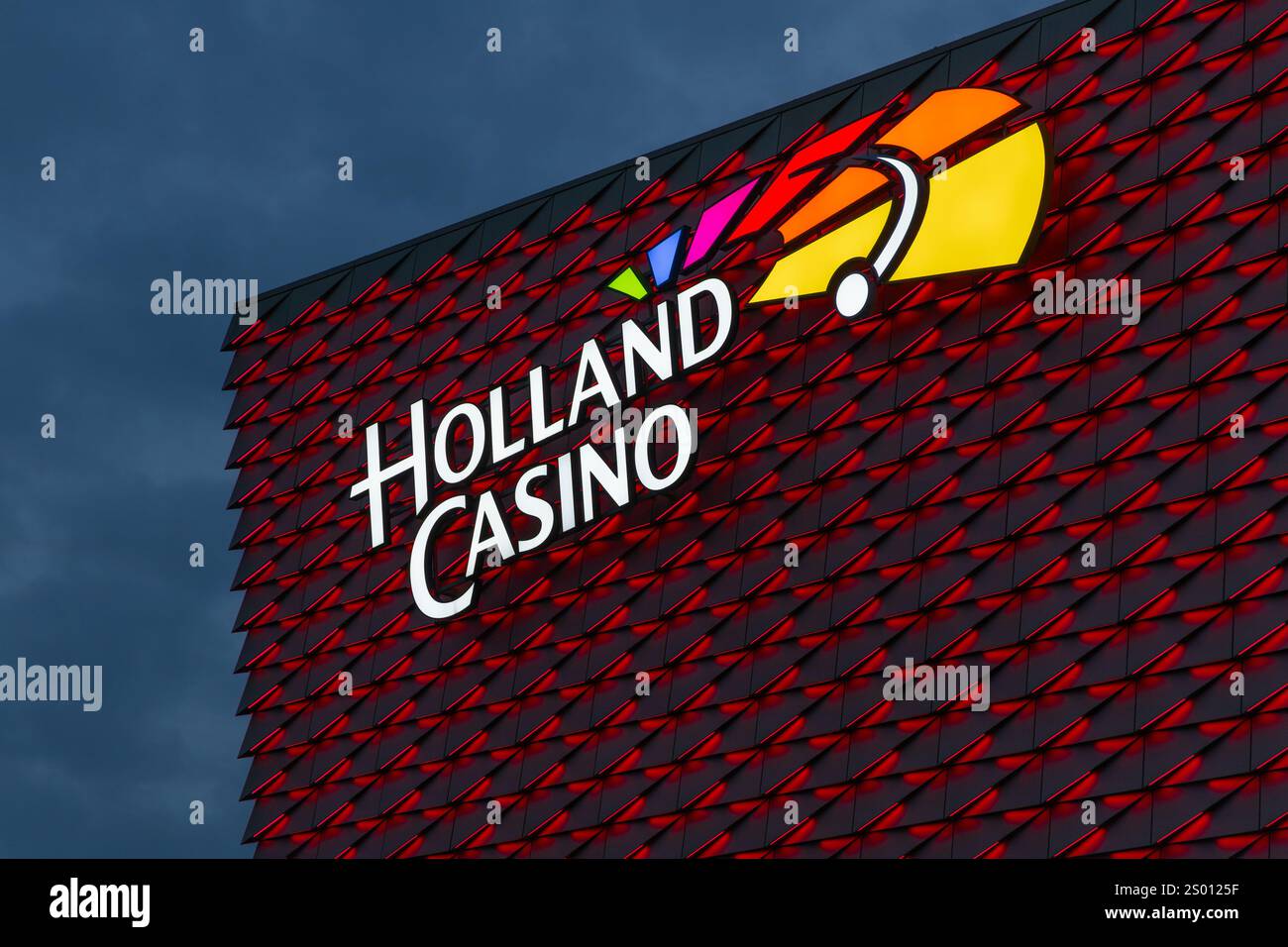 Utrecht, Niederlande. 25. september 2024. Beleuchtetes Holland Casino-Logo auf einem modernen, rot beleuchteten Gebäude. Stockfoto