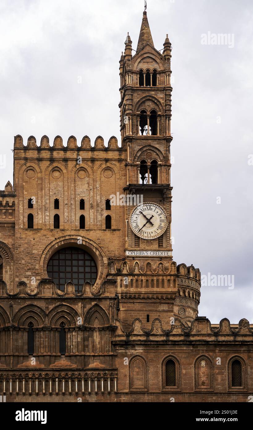 Ein Blick aus der Nähe auf ein historisches Gebäude mit einem Uhrenturm, komplizierten architektonischen Details und einem bewölkten Himmel im Hintergrund. Stockfoto