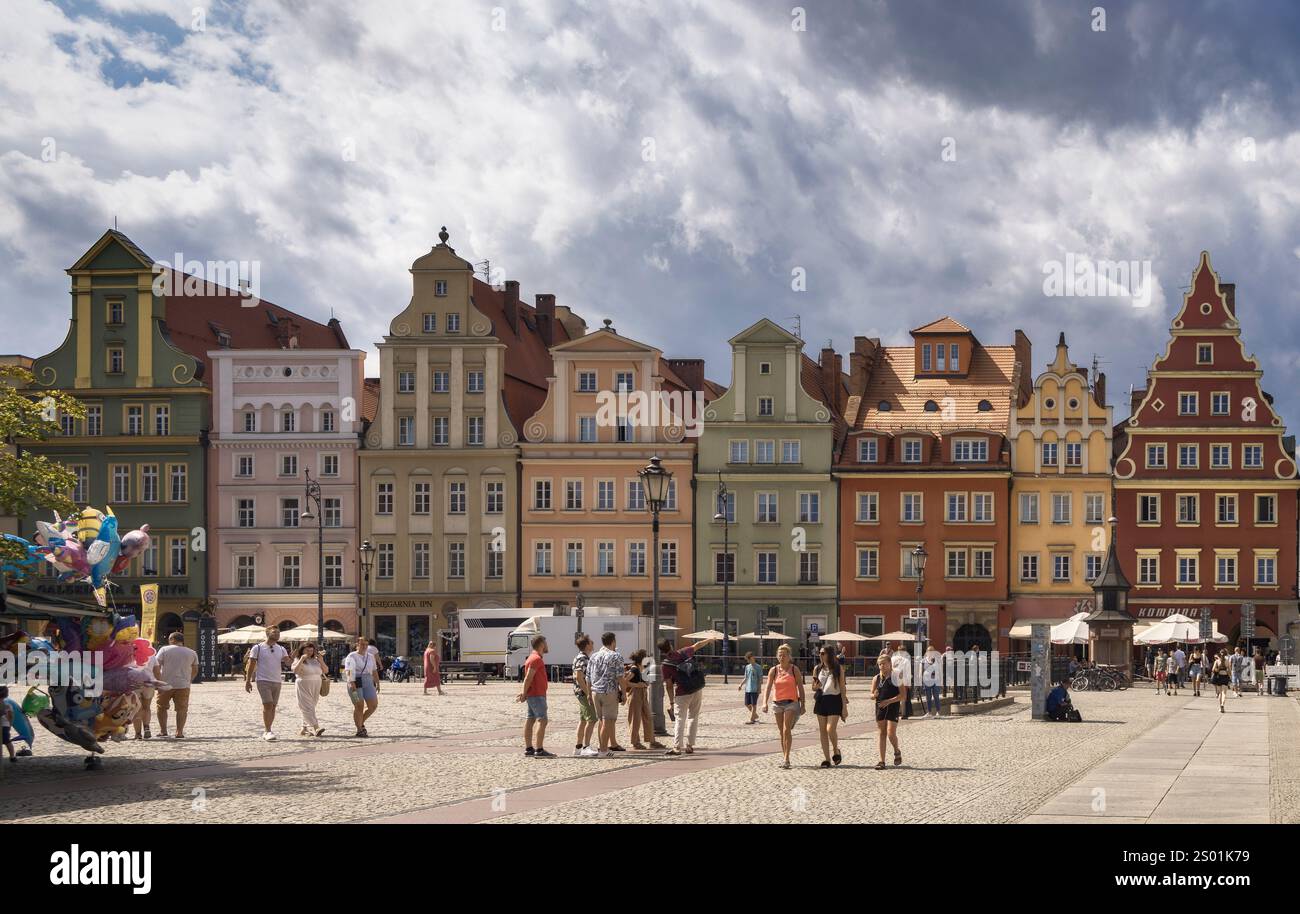 Die Menschen versammeln sich auf dem Breslauer Marktplatz und genießen die farbenfrohen Gebäude und die lebhafte Atmosphäre in Polen Stockfoto