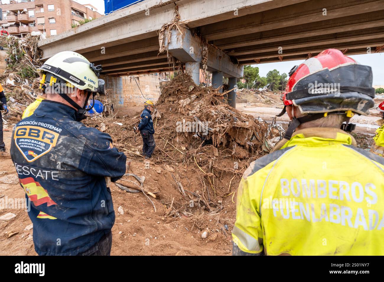 DANA-Flutungseffekte. Valencia, Spanien. Mitglieder des Rettungsteams der Hundeabteilung der Feuerwehr, die auf der Suche nach vermissten Personen in Trümmern und Schlamm auf dem Flussbett sind Stockfoto