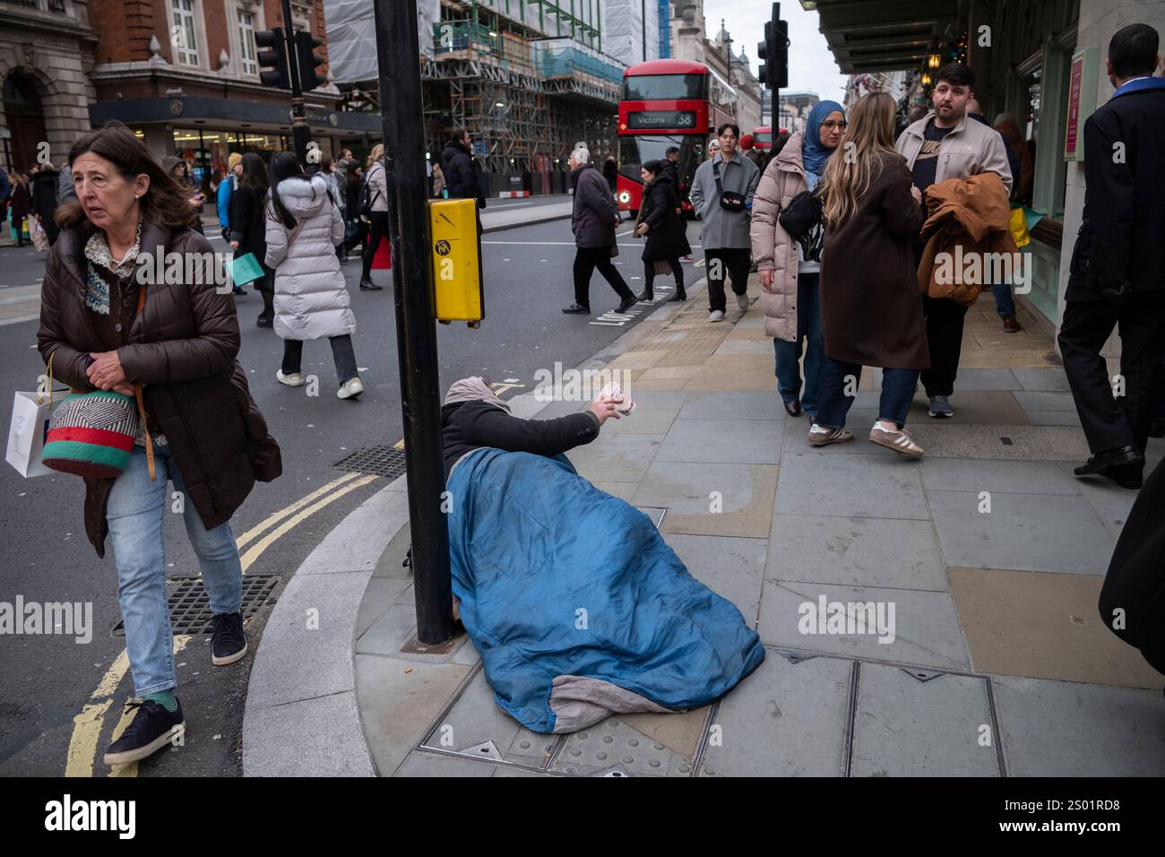 Obdachloser nimmt einen Becher, um Geld von Passanten außerhalb von Fortnum & Mason auf Piccadilly, Mayfair, im Zentrum von London, England, zu sammeln Stockfoto Obdachloser nimmt einen Becher, um Geld von Passanten außerhalb von Fortnum & Mason auf Piccadilly, Mayfair, im Zentrum von London, England, zu sammeln Stockfoto