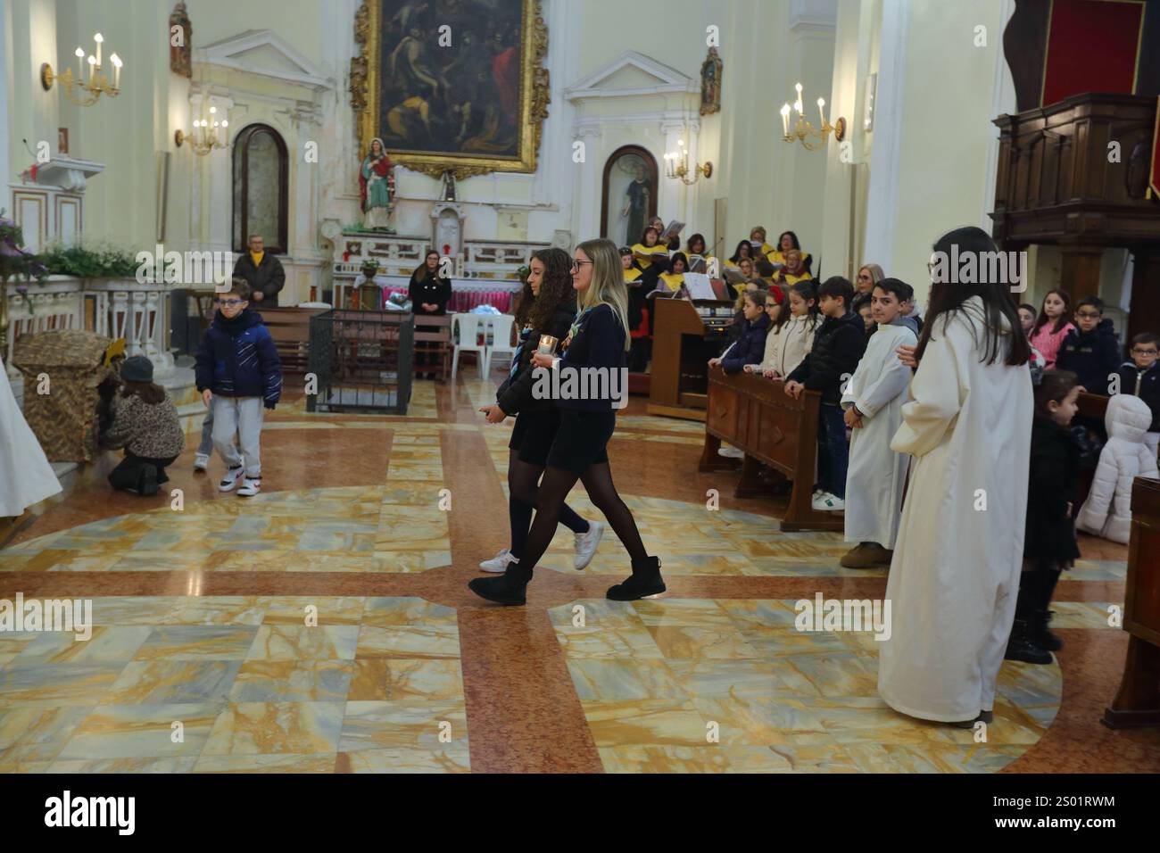 Das Licht des Friedens, das von Bethlehem kommt , wird den Gläubigen am Heiligabend dargebracht . Mädchen von Boyscout zünden die Kerze des Friedens an. Stockfoto