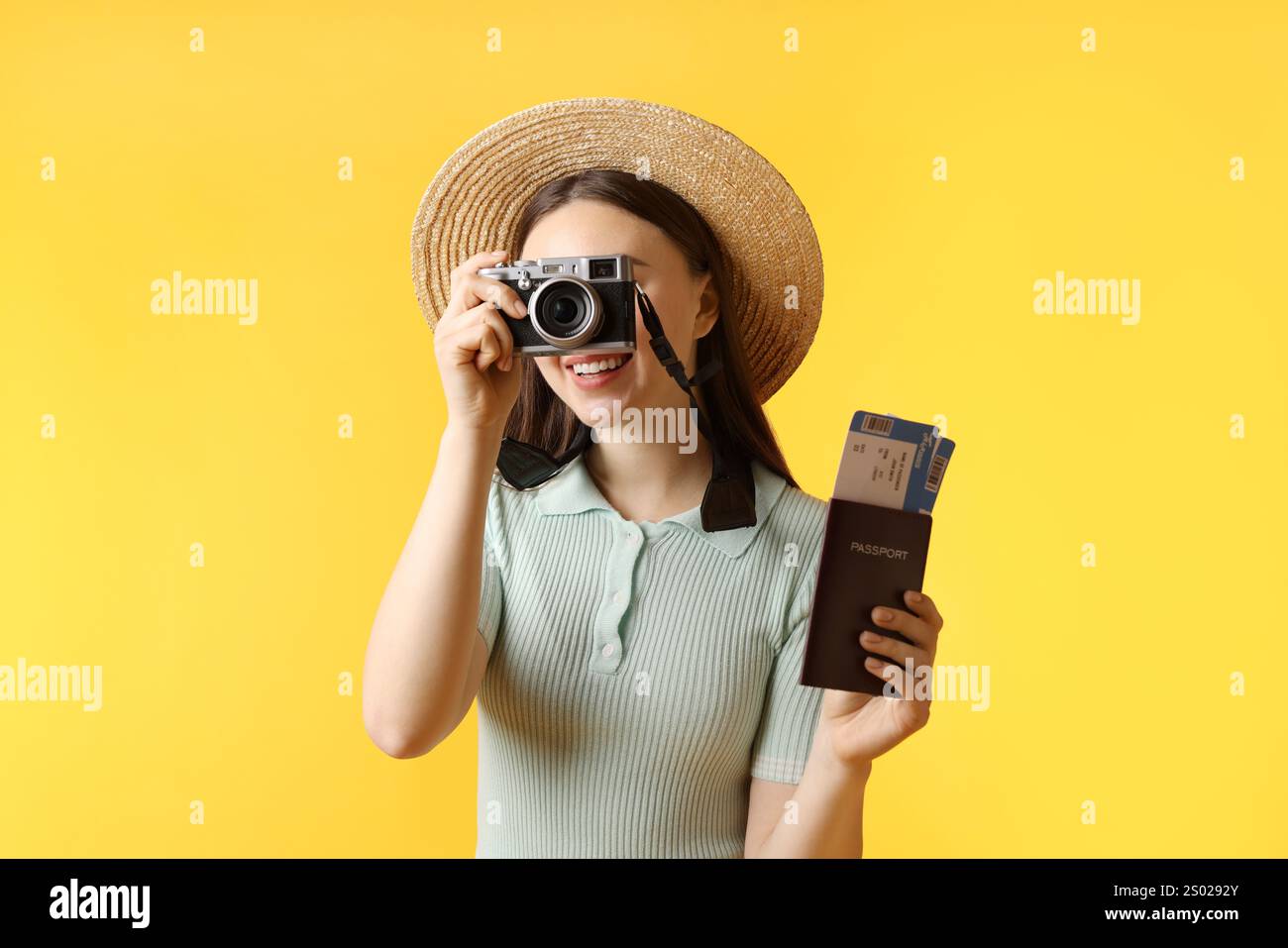 Frau mit Tickets, Pass und Vintage-Kamera auf orangem Hintergrund Stockfoto