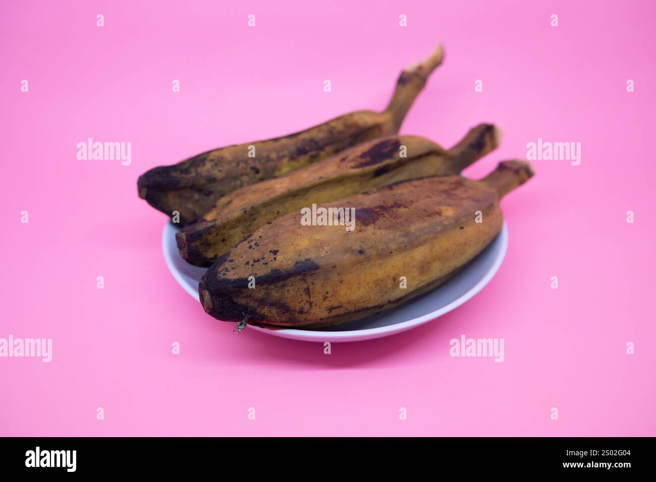 Köstliche und gesunde gekochte Bananen auf rosa Hintergrund Stockfoto