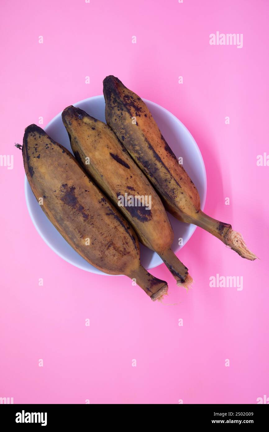 Köstliche und gesunde gekochte Bananen auf rosa Hintergrund Stockfoto