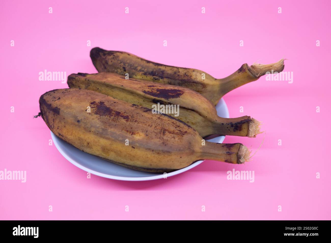 Köstliche und gesunde gekochte Bananen auf rosa Hintergrund Stockfoto