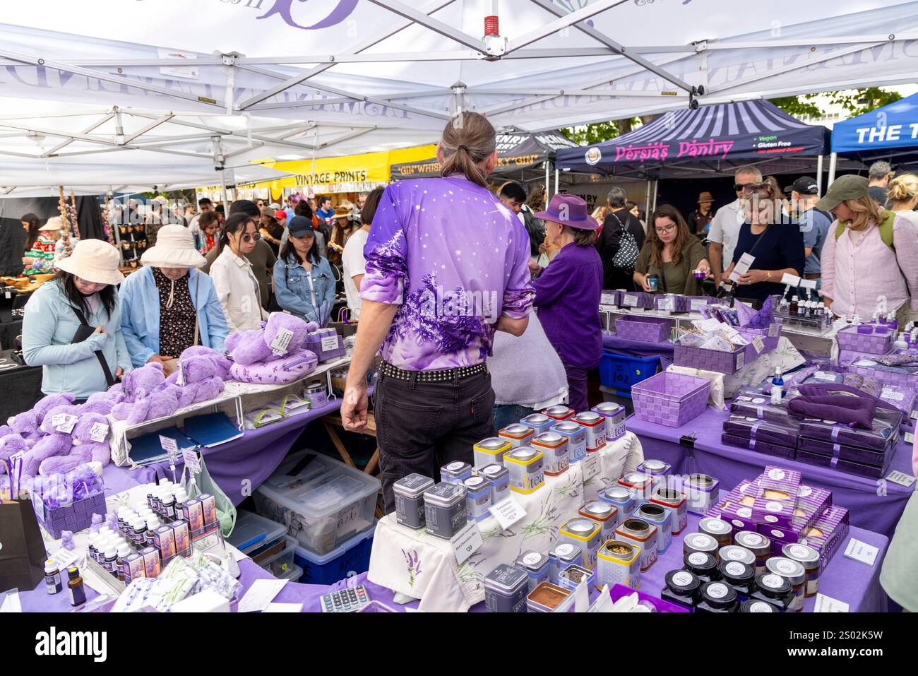 Marktstand mit Lavendelwaren und Angestellte tragen passende lilafarbene Kleidung, Salamanca Place Market in Hobart, Tasmanien, Australien Stockfoto