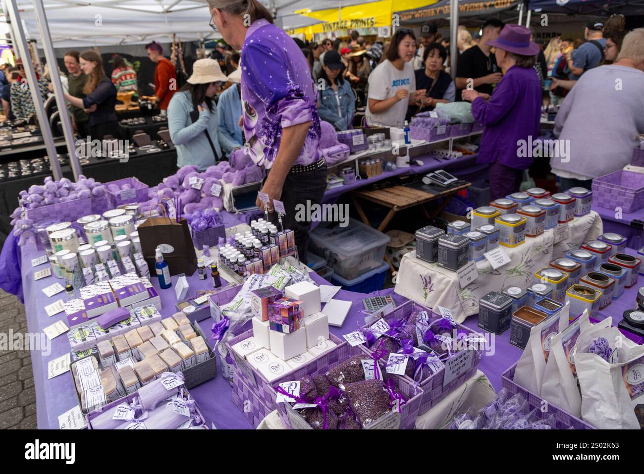 Marktstand mit Lavendelwaren und Angestellte tragen passende lilafarbene Kleidung, Salamanca Place Market in Hobart, Tasmanien, Australien Stockfoto