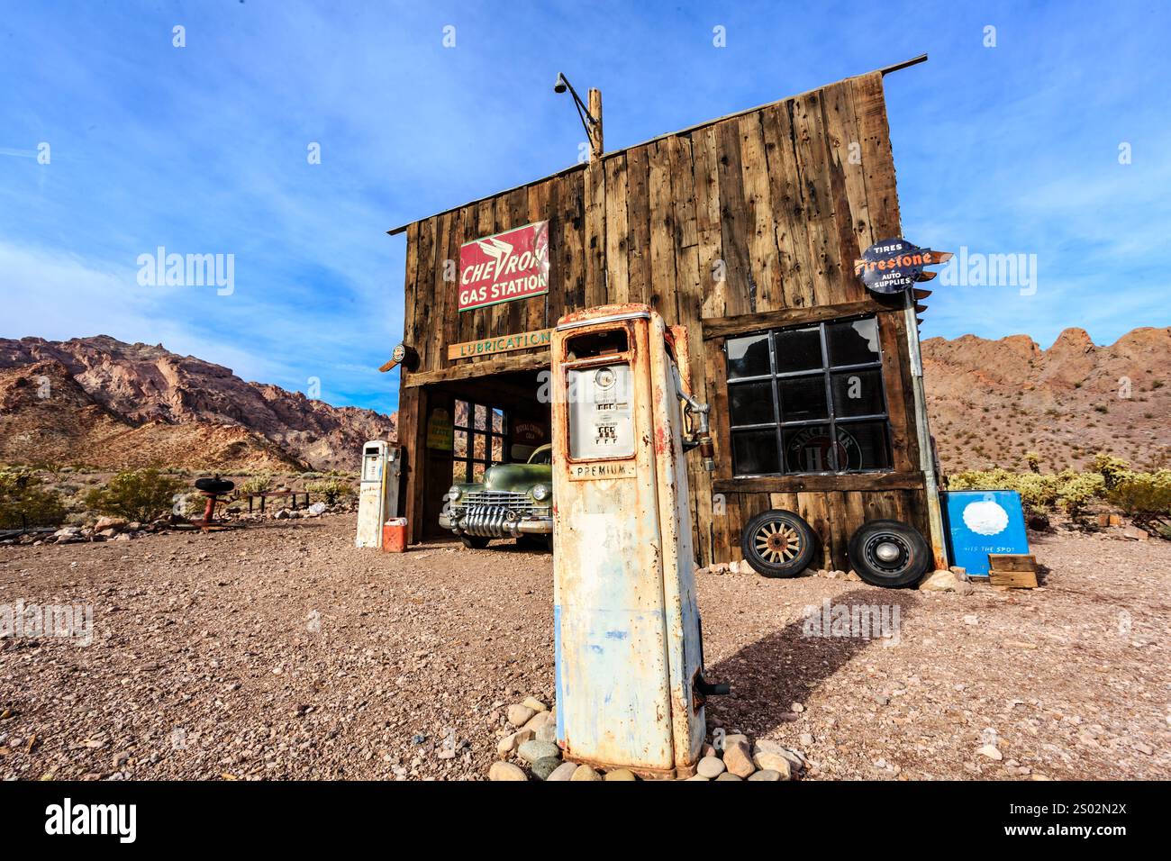 Ein rustikales Gebäude mit einer Tankstelle und einem Auto. Das Gebäude ist alt und hat ein rot-weißes Schild Stockfoto