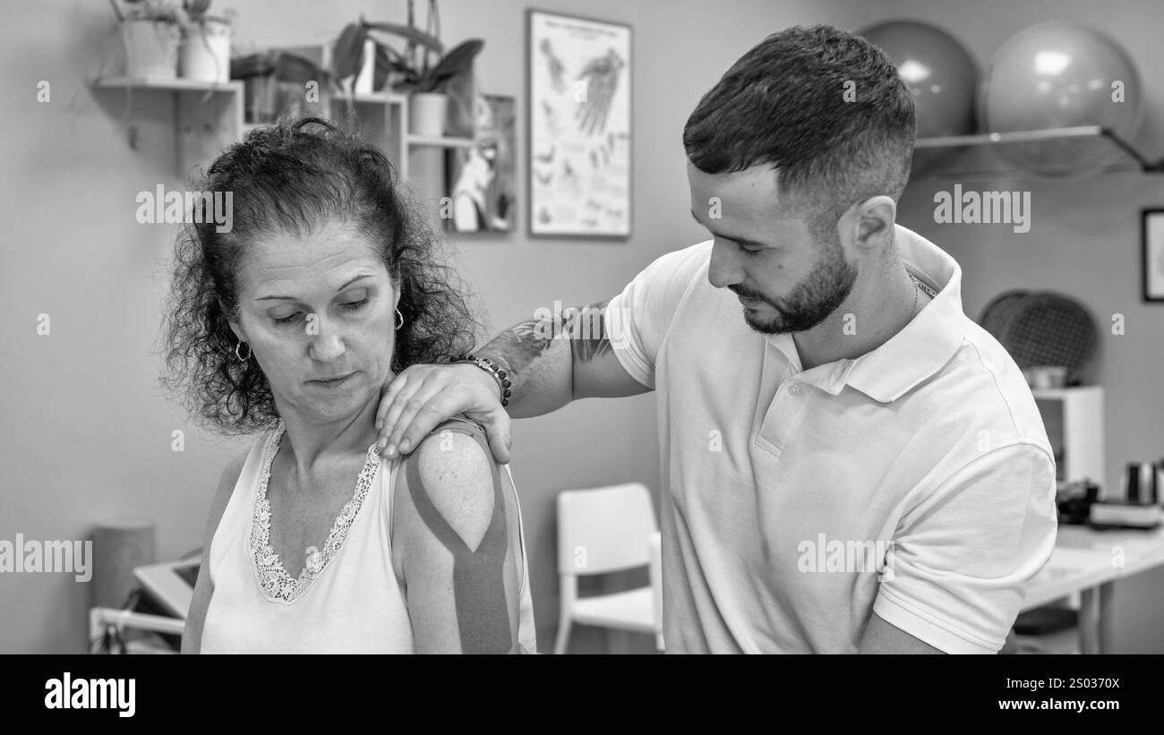 Elastisches Band um Arm und Schulter wickeln, Physiotherapie. Stockfoto