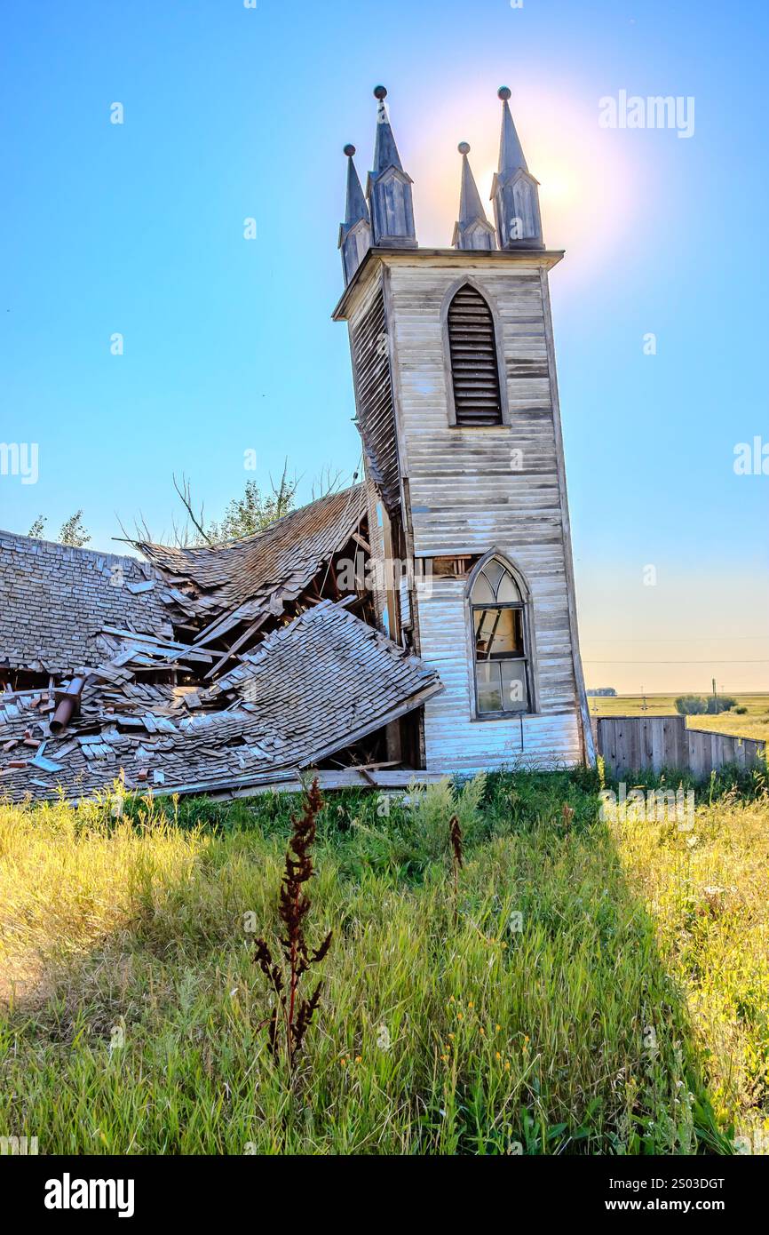 Eine Kirche mit einem kaputten Dach und einem großen Bogen. Die Kirche ist alt und verlassen. Die Sonne scheint auf die Kirche und lässt sie noch öder aussehen Stockfoto