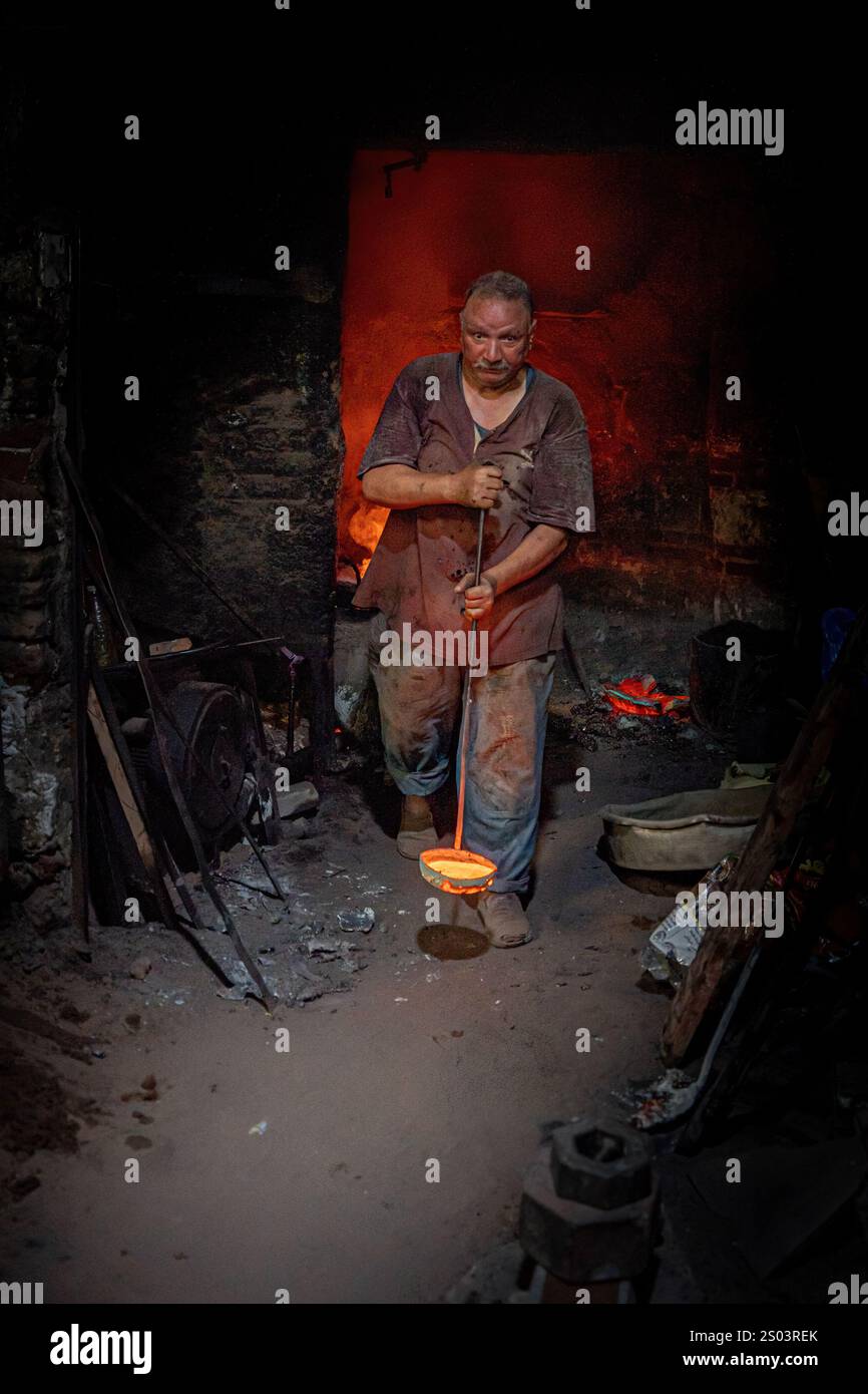 Ein Gießereiarbeiter in einer Werkstatt in Alexandria, Ägypten, der geschmolzenes Metall während eines Gießprozesses gekonnt handhabte. Ein großes Gründerbild Stockfoto