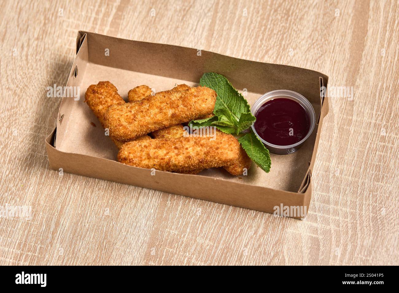 Goldbraune, knusprige Hähnchenfinger serviert mit einer würzigen Dippsoße. Stockfoto