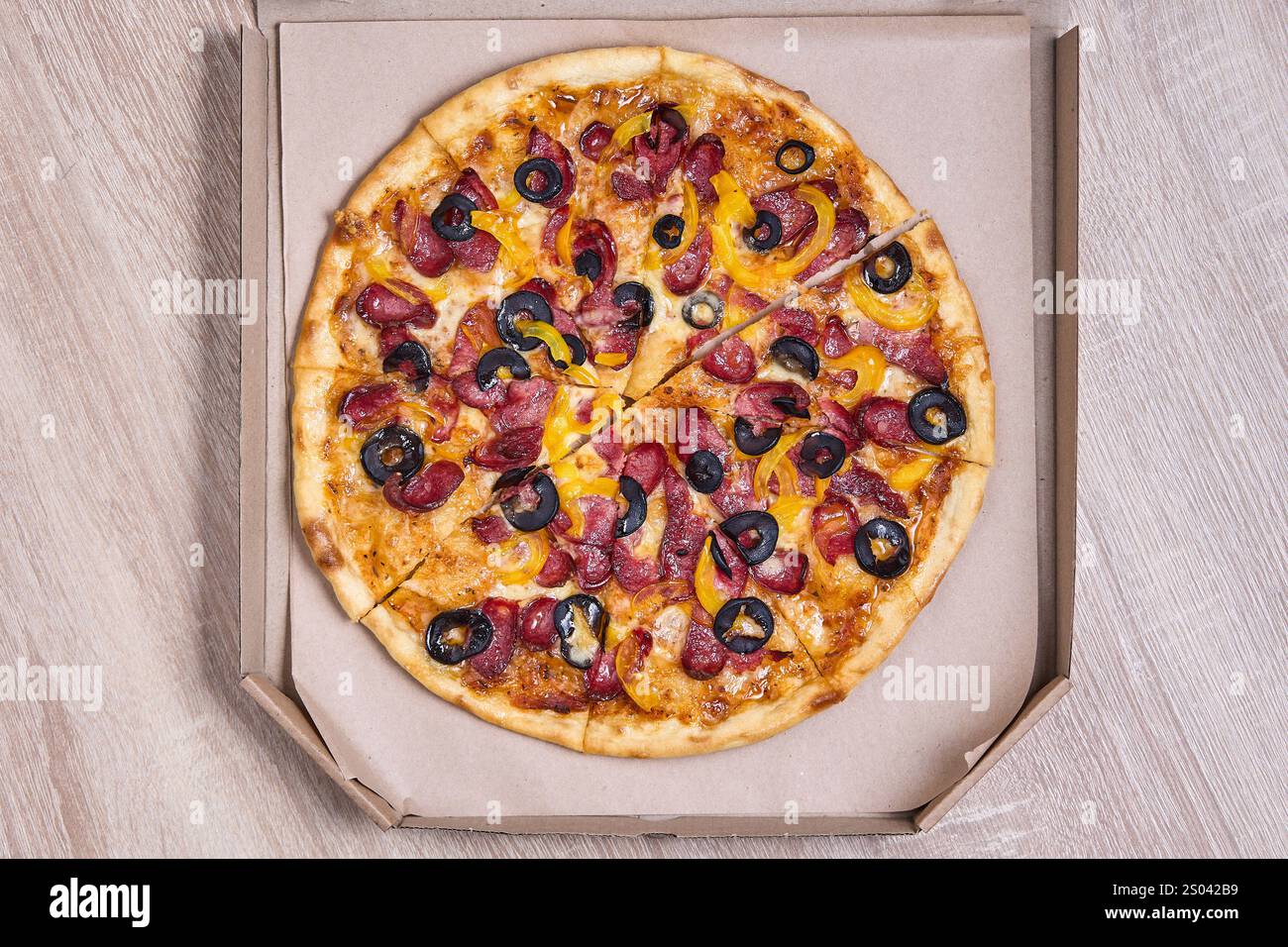 Pizza mit Paprika, Paprika und Oliven, verpackt in einem Karton. Stockfoto