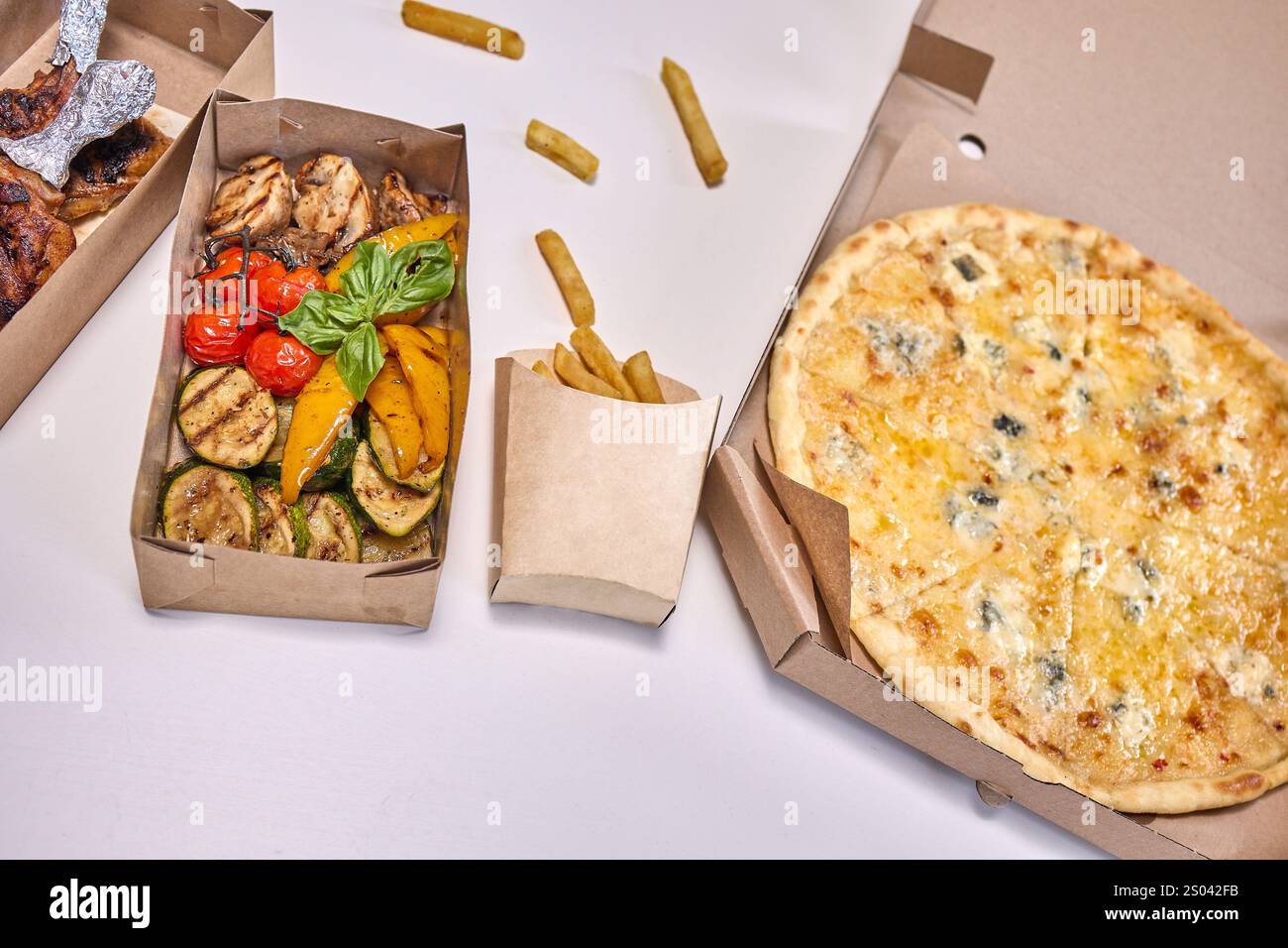 Eine flache Lage mit beliebten Fast Food-Artikeln wie Burgern, Pizza und Huhn, bereit für die Lieferung. Stockfoto