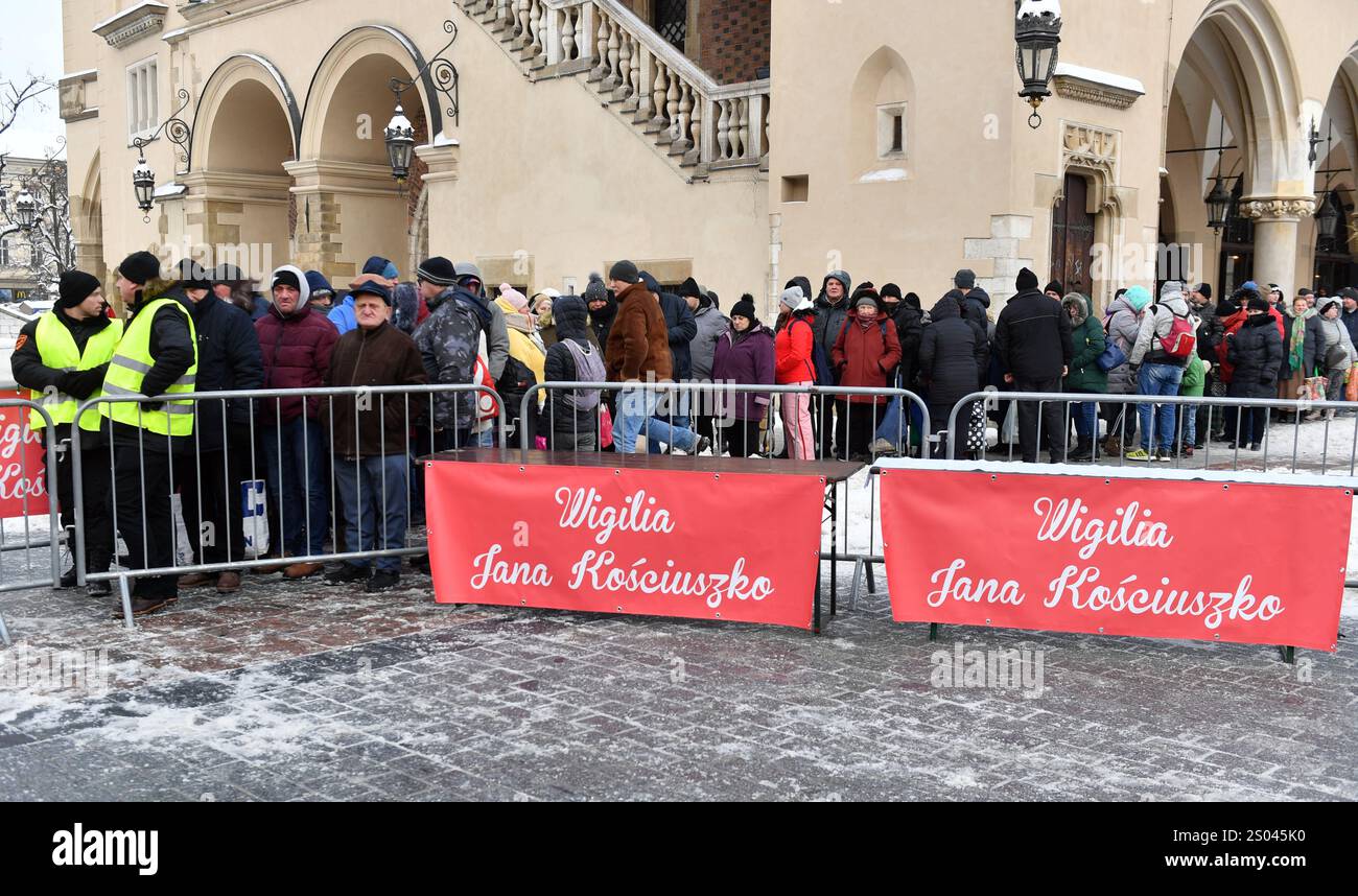 Menschen, die beim Servieren von Mahlzeiten in der Schlange stehen. Zum 26. Mal organisierte Jan Kosciuszko, ein Gastronom, Geschäftsmann und Philanthrope, in Krakau einen Heiligabend für Bedürftige auf dem Krakauer Hauptmarkt. Über 50.000 Portionen und Pakete wurden ausgegeben. (Foto: Alex Bona / SOPA Images/SIPA USA) Stockfoto