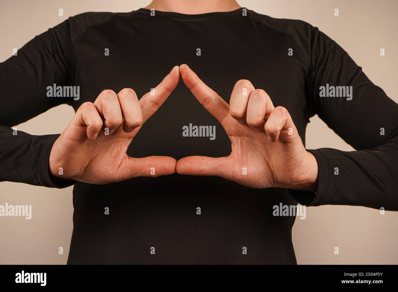 Die Finger beider Hände vereinen sich zu einer Herzform und vermitteln Wärme und Anhaftung. Die Geste spiegelt Harmonie und emotionale Bindung wider. Die saubere, neutrale B Stockfoto