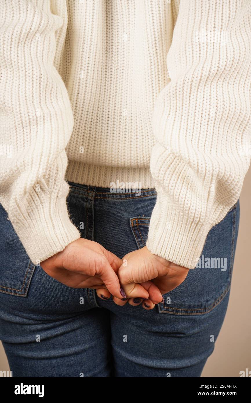 Zwei Hände greifen ihre Finger zu einer geschlossenen Haltung. Diese kraftvolle Geste zeigt Solidarität und Engagement. Vor neutralem Hintergrund, t Stockfoto